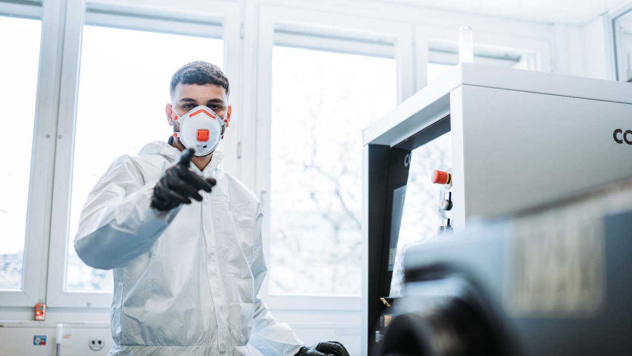 A technician ready to harvest medical devices printed with fine titanium powder